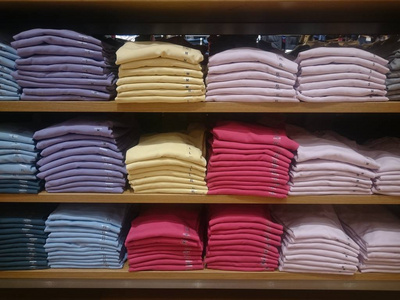 s multicolored knitted shirts on store shelves Closeup