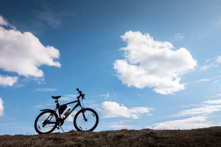 蓝天上的自行车轮廓与云彩。独立和自由的象征