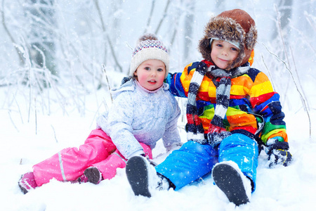 两个可爱的小孩男孩和女孩在冬天的雪森林雪花背景。户外休闲和生活方式与孩子们在寒冷的雪天。愉快的兄弟姐妹, 兄弟和姐妹演奏