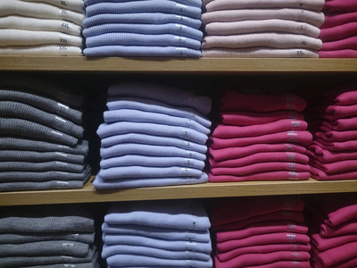 s multicolored knitted shirts on store shelves Closeup