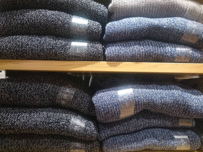 s multicolored knitted shirts on store shelves Closeup