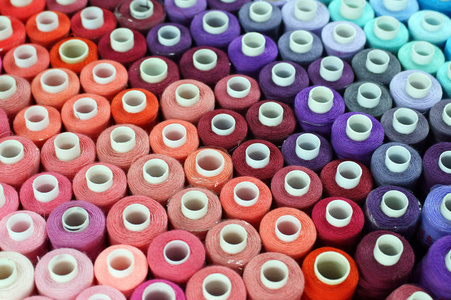 木制背景上的多色缝纫线照片
