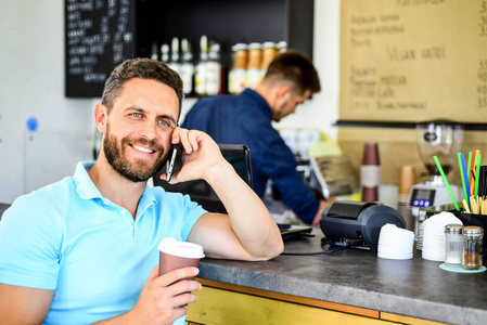 等着你呢男人智能手机在咖啡馆点咖啡。咖啡休息的概念。咖啡带走了忙碌的人的选择。人移动对话咖啡馆咖啡师背景。在等待的时候喝咖啡