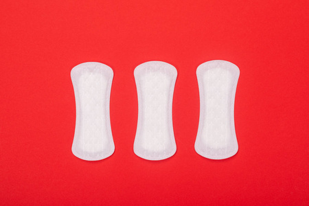 螺母柱垫片,公螺纹和阴螺纹,装在塑料容器中一堆女性卫生巾在粉红色的