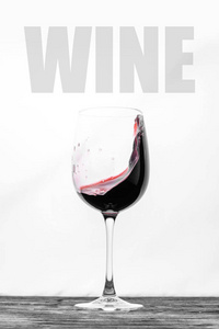 杯子里的红酒在白色的背景上飞溅。 带文字的时尚设计卡