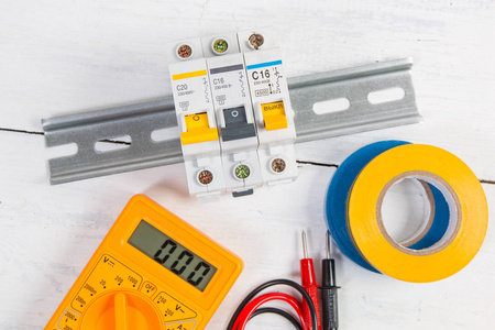 电气模块化断路器绝缘胶带和数字万用表。电网保护和切换