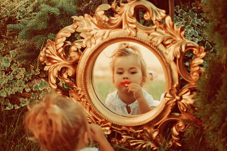 婴孩女孩化妆面在镜子上的自然景观