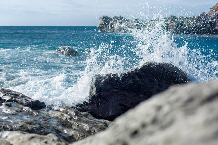 大西洋的波浪正在西班牙兰萨罗特岛上的冷却熔岩上飞溅。