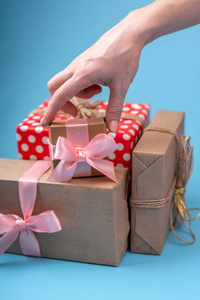 s hands holding gift boxes Packed in Kraft paper with pink ribbo