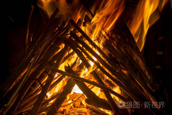 燃烧的木材原木关闭作为抽象的背景. 燃烧木材原木火的炽热余烬.