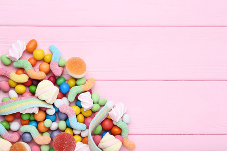 粉红木桌上五颜六色的糖果