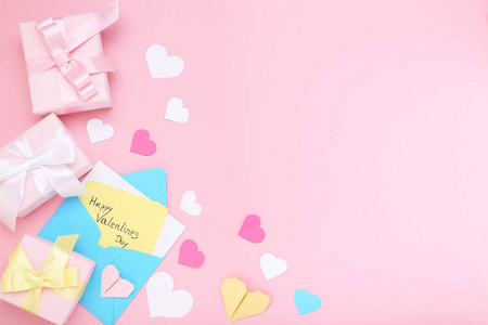 情人节快乐，有礼品盒和粉色背景的信封