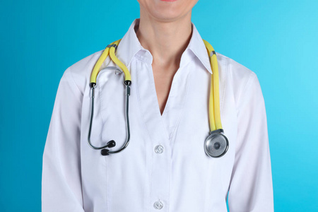女性医生用听诊器进行彩色背景特写。 医疗器械