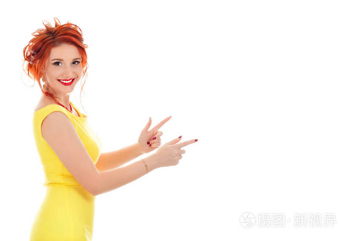快乐美丽的年轻女子指着一边手指孤立在白色工作室的背景上看这里手势