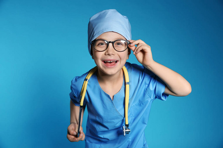 穿着医生制服的可爱小孩，在彩色背景上用听诊器