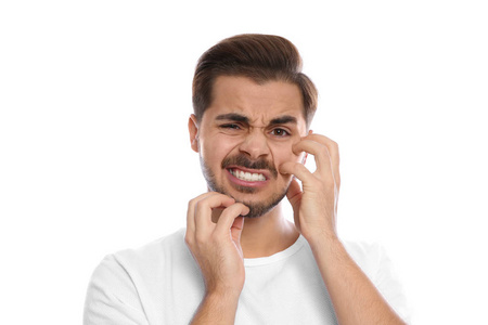 年轻人在白色背景上抓脸.烦人的痒照片