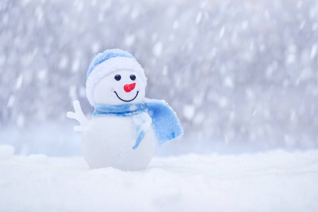 冬天戴着帽子的小雪人和雪上的围巾. 带雪球的快乐雪人.