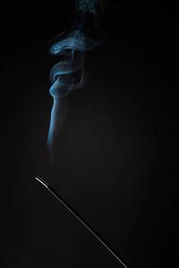 熏香棒和烟雾上升的黑色背景。 纯松弛主题烟蒸汽烟波雾效