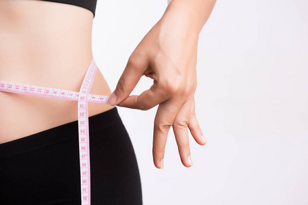 胖女人用白色的量带测量腰部，减轻多余的体重。 医疗保健和体育理念。
