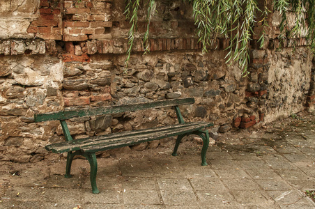 被忽视的小山村废弃的砖土墙背景上破旧的木凳