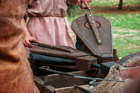 中世纪铁匠使用一对波纹管在铁匠铺炉中点火. 重建照片