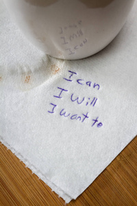 手写的纸条上的咖啡染色餐巾纸与一个授权的信息，我可以，我会想。