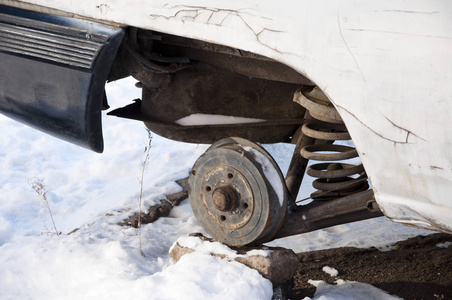 白色冬季雪地上的无轮破碎汽车