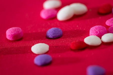 一组可食用的小糖的宏在不同的红白缬装饰背景中