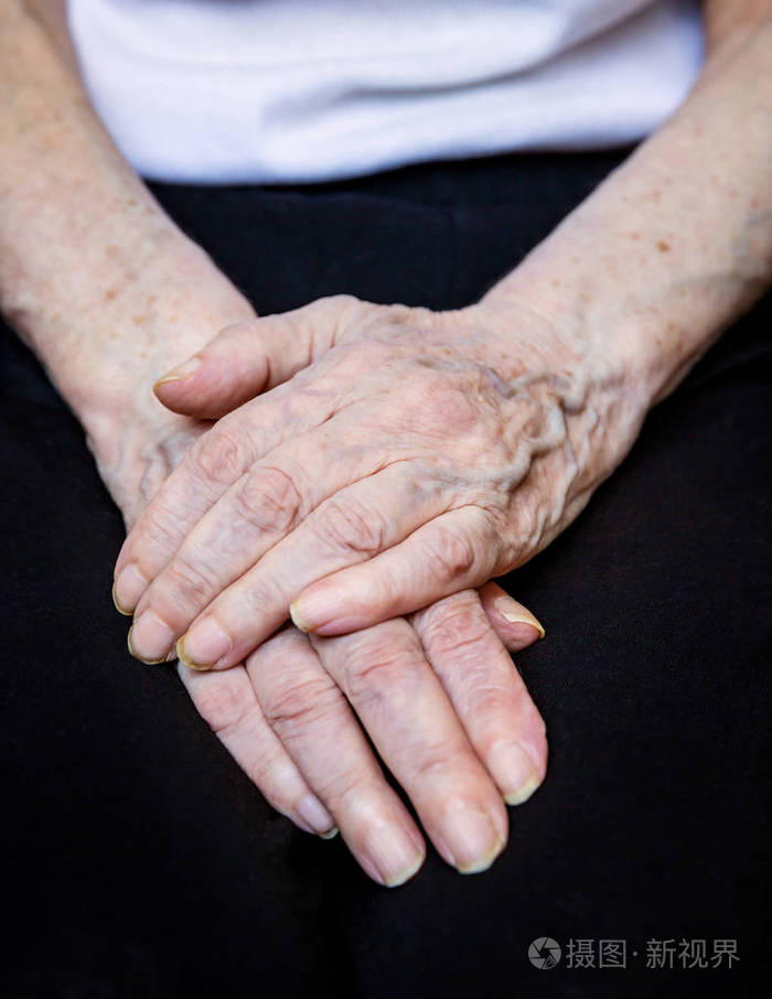 在黑色背景上靠近老年女性的手