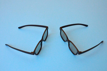 两个黑色眼镜在蓝色背景上互相映衬。 太阳镜3D眼镜用于电影院的眼睛对眼睛