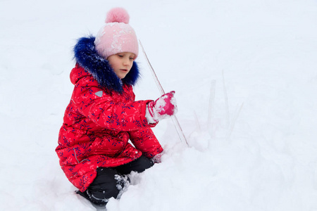 冬天，一个女孩在雪地里玩冰