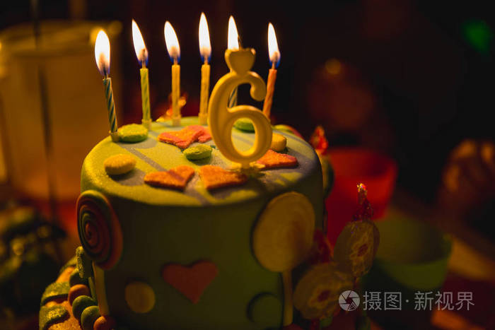 生日五彩蛋糕点燃蜡烛6岁蜡烛黑暗背景糖果装饰