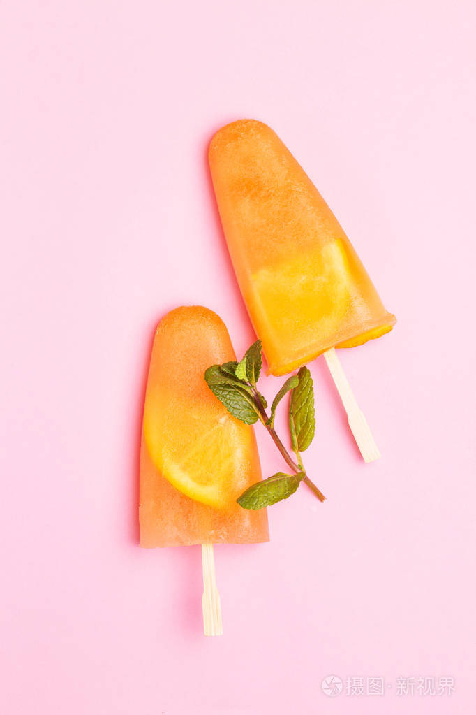 自制橘色冰糕里面有橙片和新鲜薄荷浅粉色背景健康的甜点无乳糖冰淇淋