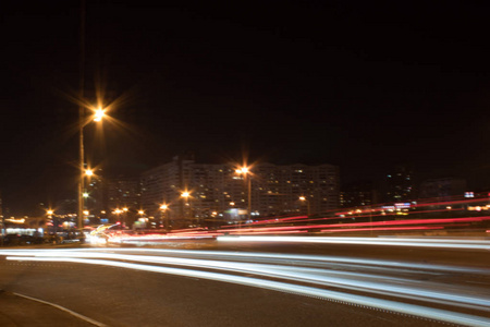 晚上的高速公路。汽车在夜间以极快的速度行驶。与灯的混合道路与汽车在高速上