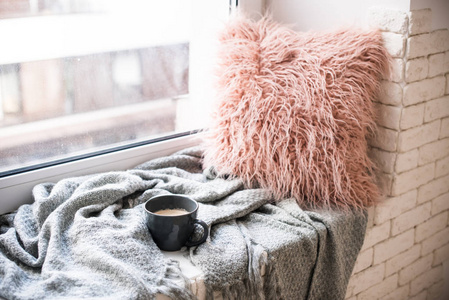 一杯咖啡, 针织毯子和蓬松的枕头上舒适的窗台