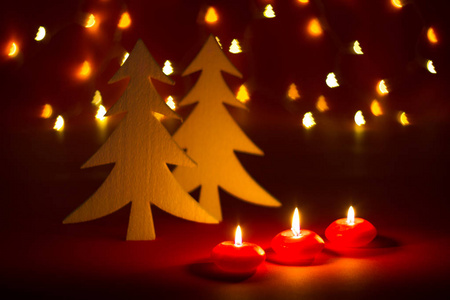 圣诞蜡烛及装饰在红色的深色背景上，形状为带灯的布克