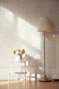 白色阁楼内部有白色砖墙灯和木制家具的花
