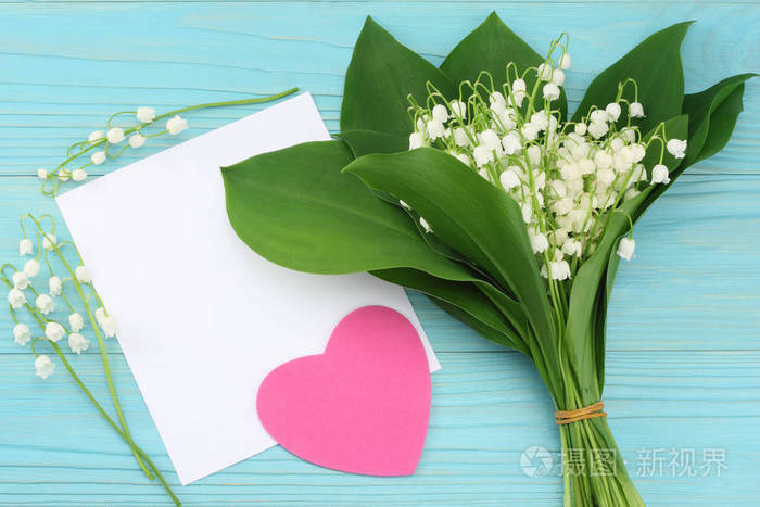 山谷里的百合花白纸上有蓝色的木制背景顶部视图复制空间