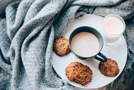 斯堪的纳维亚风格的早餐, 咖啡和饼干在舒适的窗台上与温暖的毯子和枕头