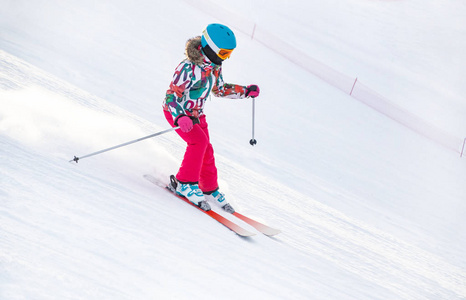 小女孩在冬季的山地度假村滑雪到滑雪坡