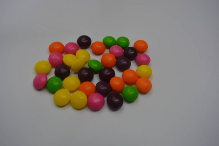 明亮的甜和美味的糖果，黄色，粉红色，橙色，绿色和紫色的窗帘在白色的背景上。