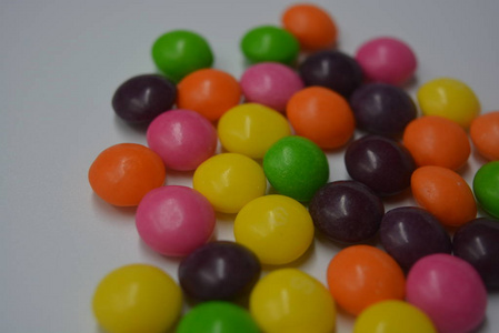 明亮的甜和美味的糖果，黄色，粉红色，橙色，绿色和紫色的窗帘在白色的背景上。