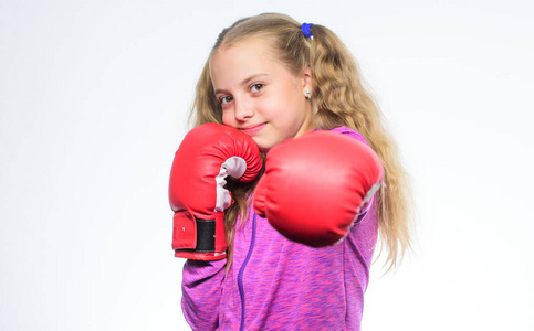 淘汰赛和能量.运动成功.小女孩在拳击手套拳打脚踢.运动服照片