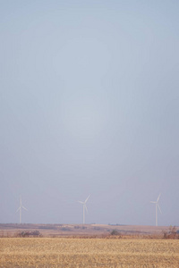 山顶上的风车涡轮机农业在前面挥舞，背景是蓝天