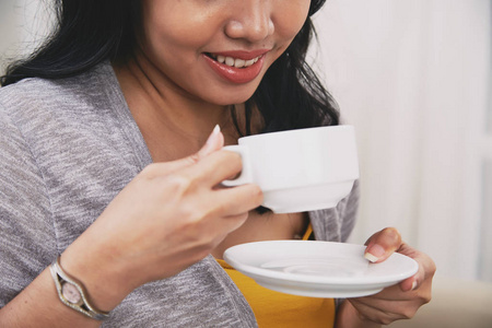 微笑的年轻女子享受一杯茶或咖啡的画面