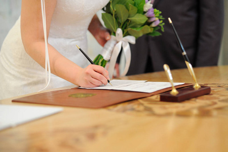 新娘把她的签名放在结婚文件里。
