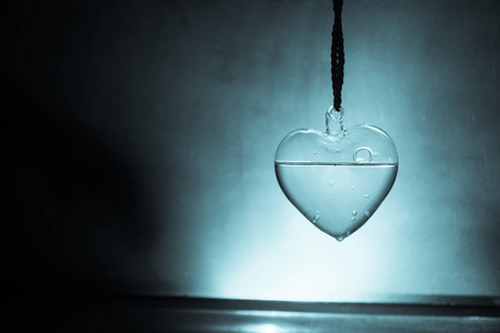 玻璃透明的心在黑暗中,玻璃心发光,玻璃画,黑色背景.