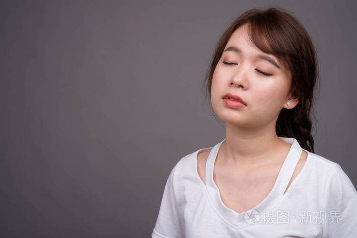 年轻美丽的亚洲女人闭着眼睛放松