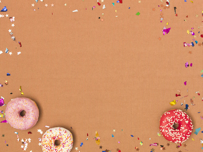 彩色棕色狂欢节背景与甜甜圈饼干和纸屑
