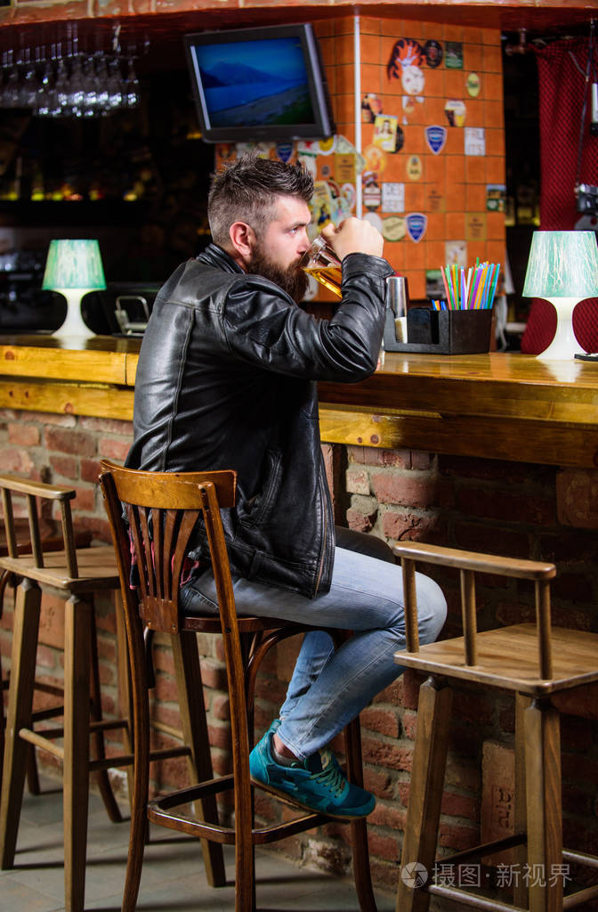 残酷的嬉皮士放松.周末的生活方式.男胡子的人坐在酒吧的酒吧柜台里.